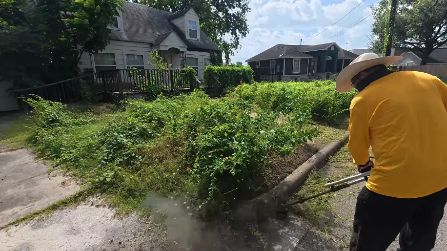 Lawn care technician performing scheduled lawn maintenance on a residential Lafayette property
